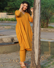 Mustard mul cotton kurta pant set with V-neck, cloth-covered buttons, pleated pattern from yoke, 3/4 sleeves, and pockets, in our best-selling design