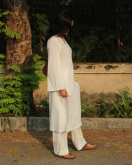 white cambric cotton co-ord set with distinctive black thread hand detail on V-neck and long bell sleeves, paired with relaxed fit pants, versatile and sustainable