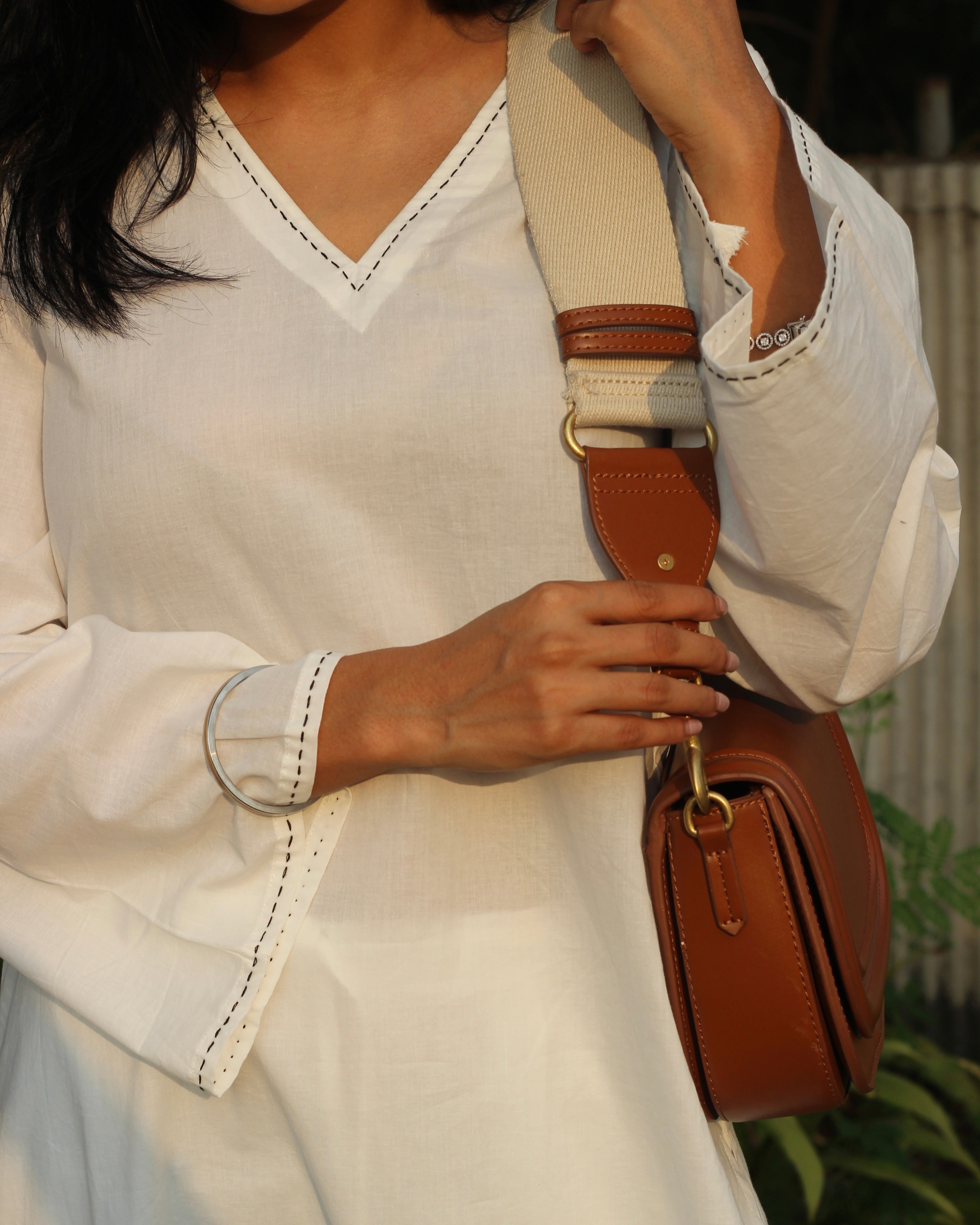 white cambric cotton co-ord set with distinctive black thread hand detail on V-neck and long bell sleeves, paired with relaxed fit pants, versatile and sustainable