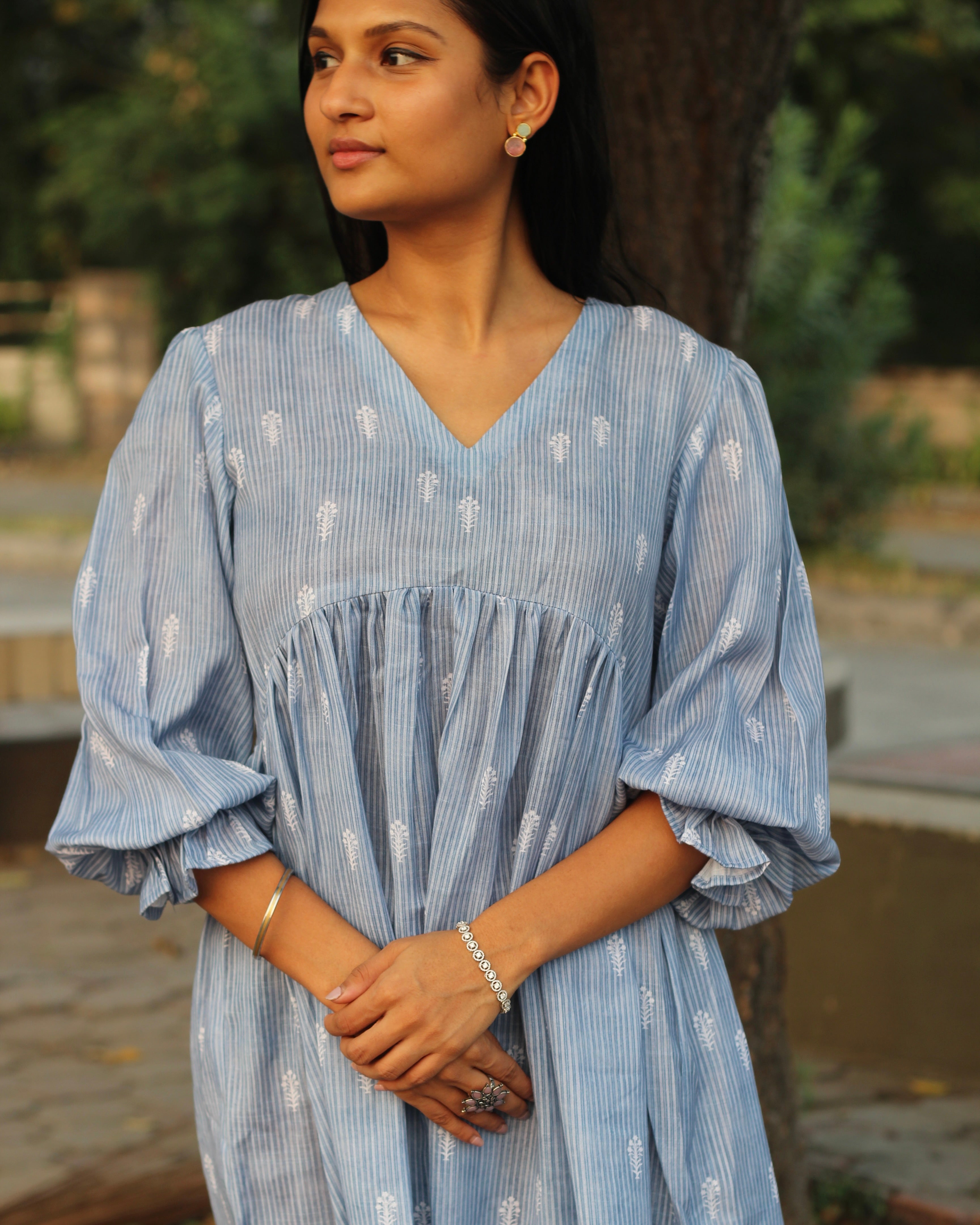 Blue stripes cotton linen dress in Alia cut with puff 3/4 sleeves and white motifs all over, showcasing our best-selling print