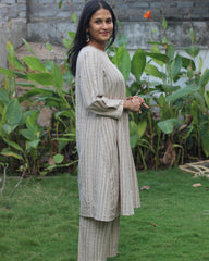 Beige handloom cotton kurta set with stripe pattern, side detail pockets, relaxed neck, and box 3/4 sleeves, paired with elastic waist pants