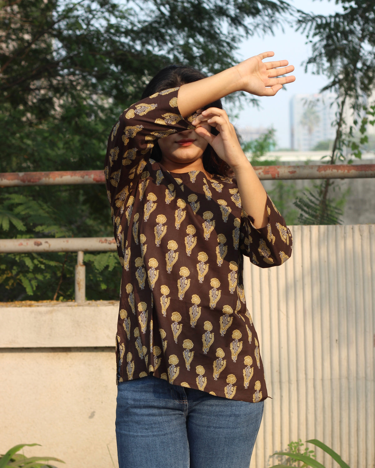 Comfortable brown printed short kurta with contrasting booti, ideal for casual outings or work wear, featuring 3/4 sleeves and a round neck.