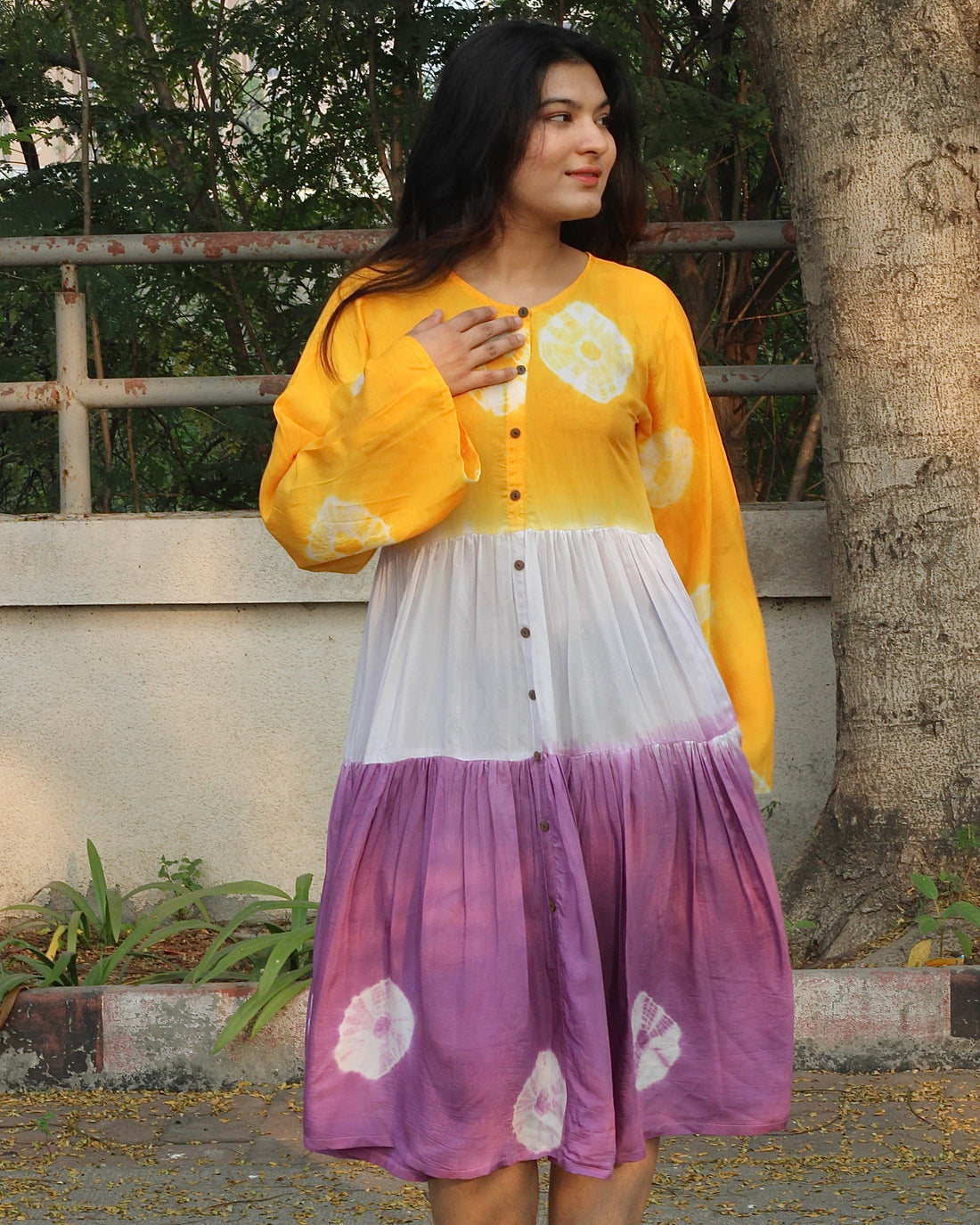 Lilac, yellow, and white bandhani print dress on a model, showcasing the intricate tie and dye design on pure muslin fabric_2