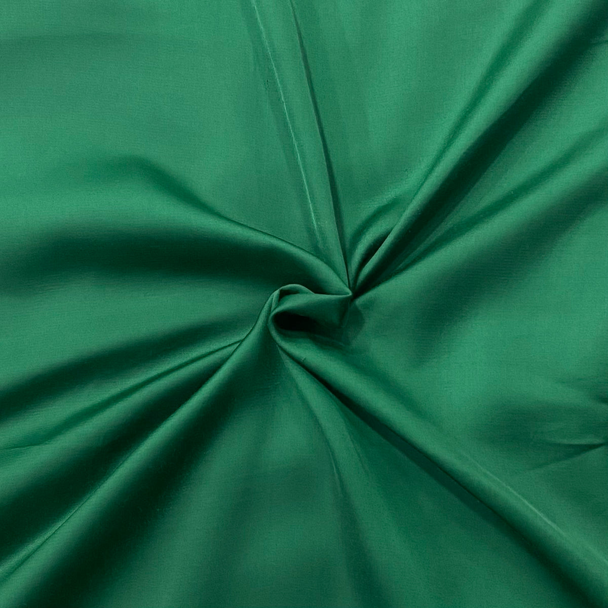 Detail shot of Lush Green Modal Satin's glossy surface, showcasing the luxurious sheen