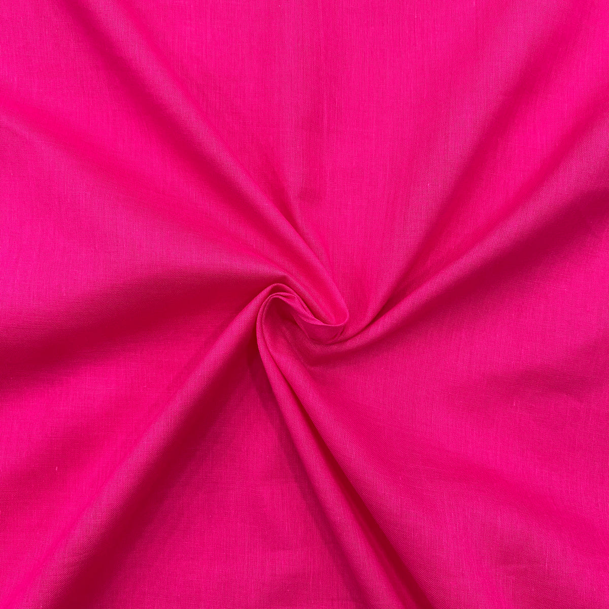 Vibrant hot pink mul cotton fabric displayed on a white background, emphasizing the bold color and soft texture