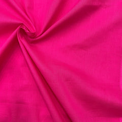 Folded hot pink mul cotton fabric, illustrating its flexibility and suitability for various sewing projects