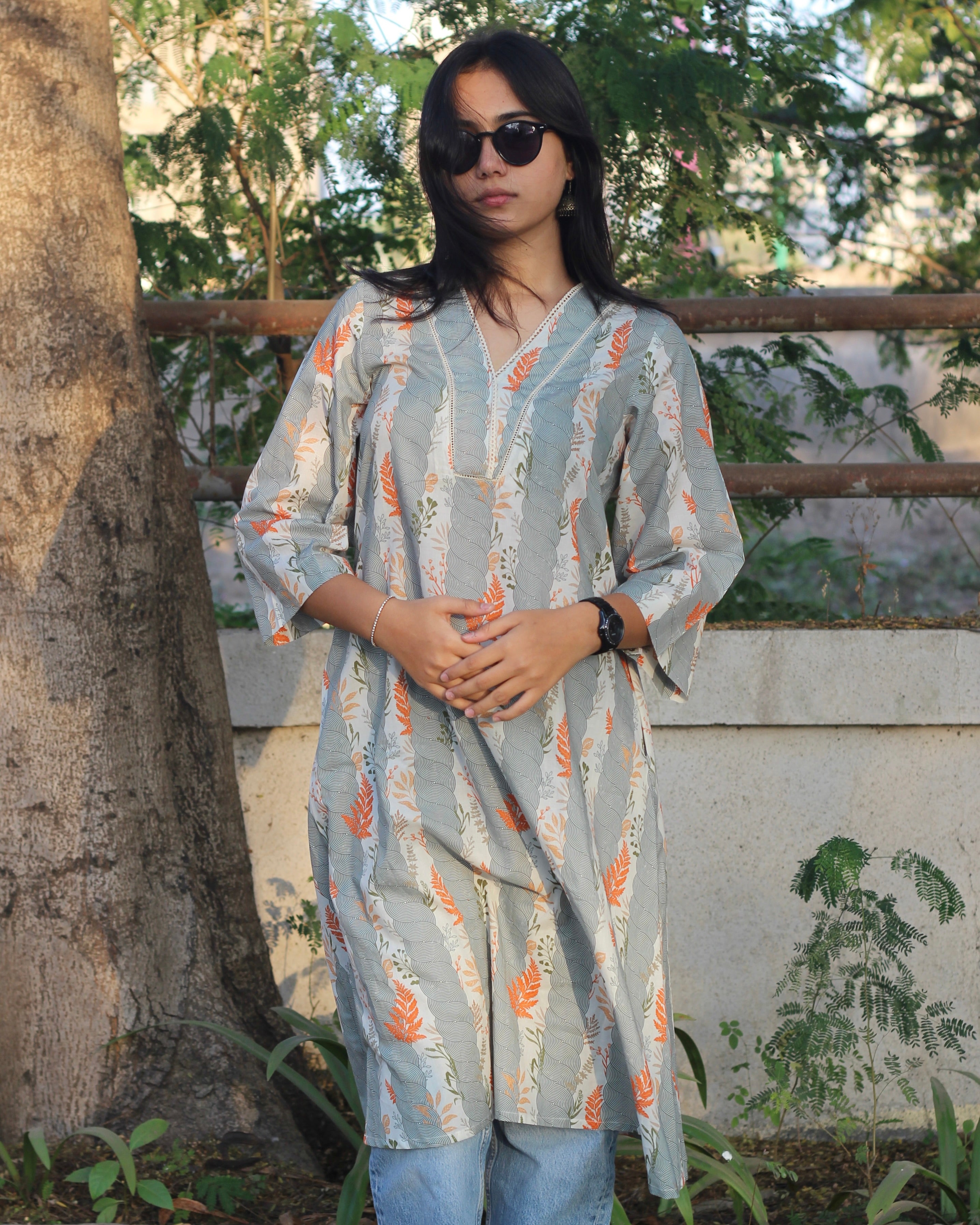 A-line long kurta in premium cotton with green stripe print, orange leaf elements, V-neck lace details, and dual pockets