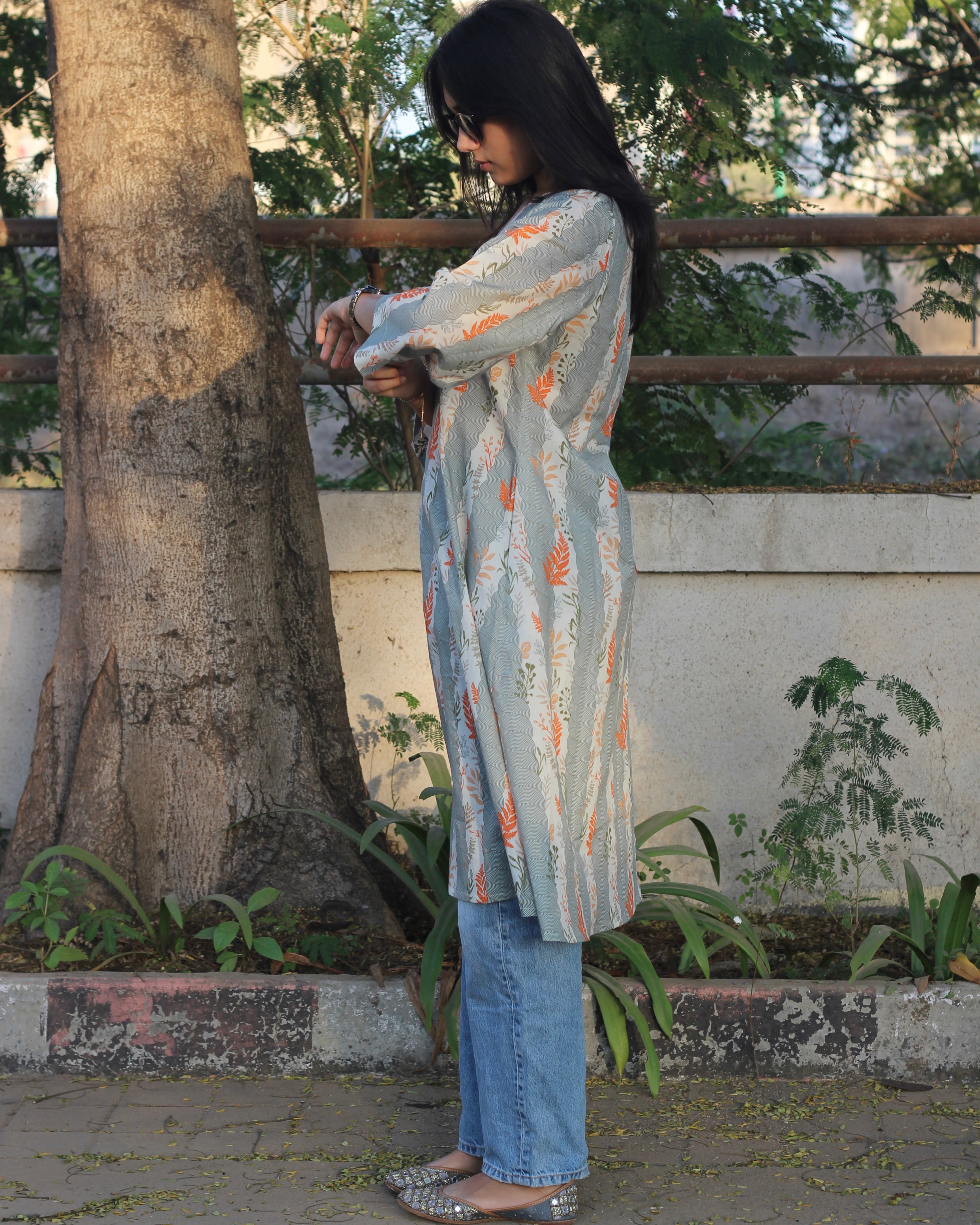 A-line long kurta in premium cotton with green stripe print, orange leaf elements, V-neck lace details, and dual pockets