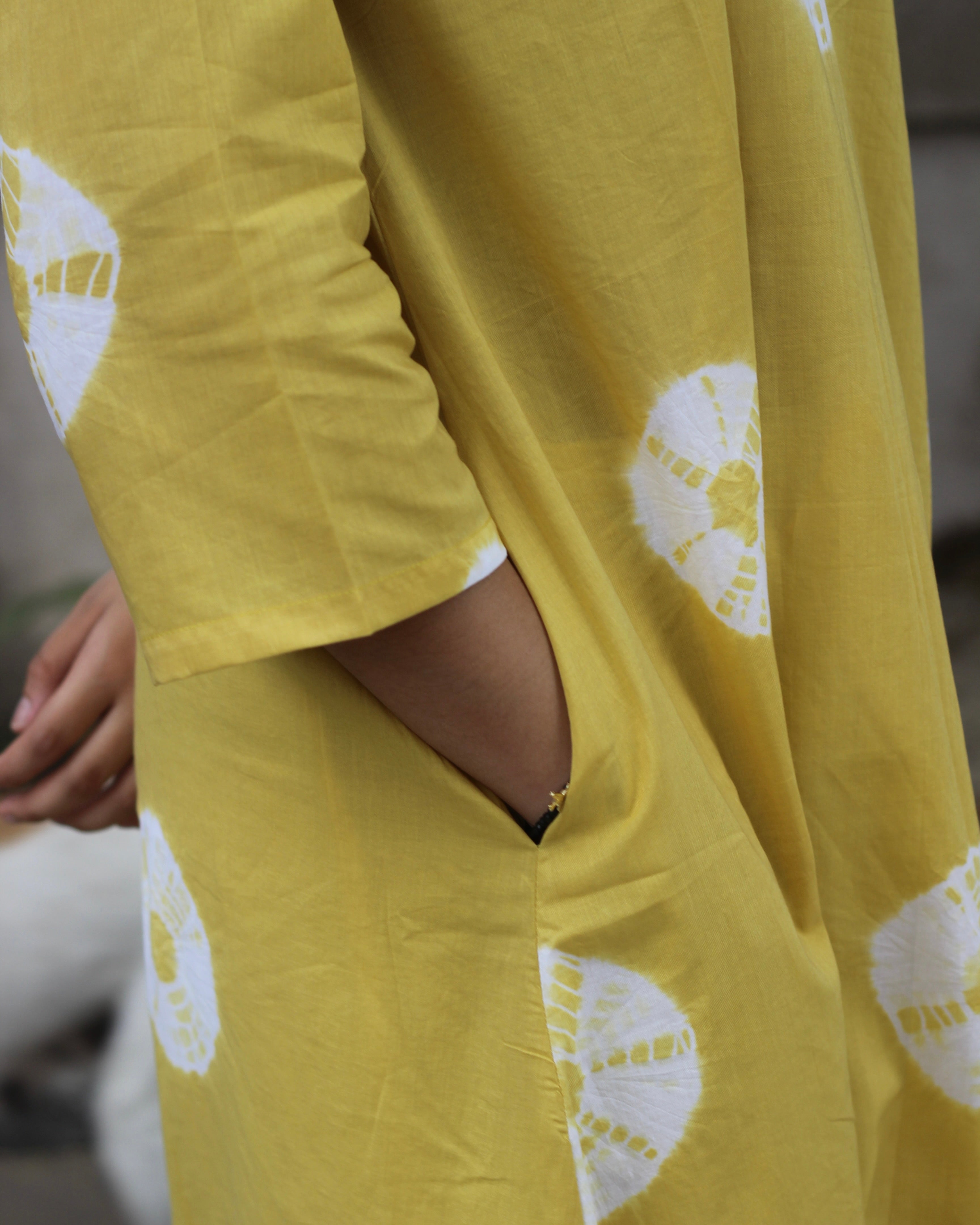 Yellow tie-dye cotton kurta with white bandhani print, V-neck, 3/4 sleeves, side pockets, and A-line design.