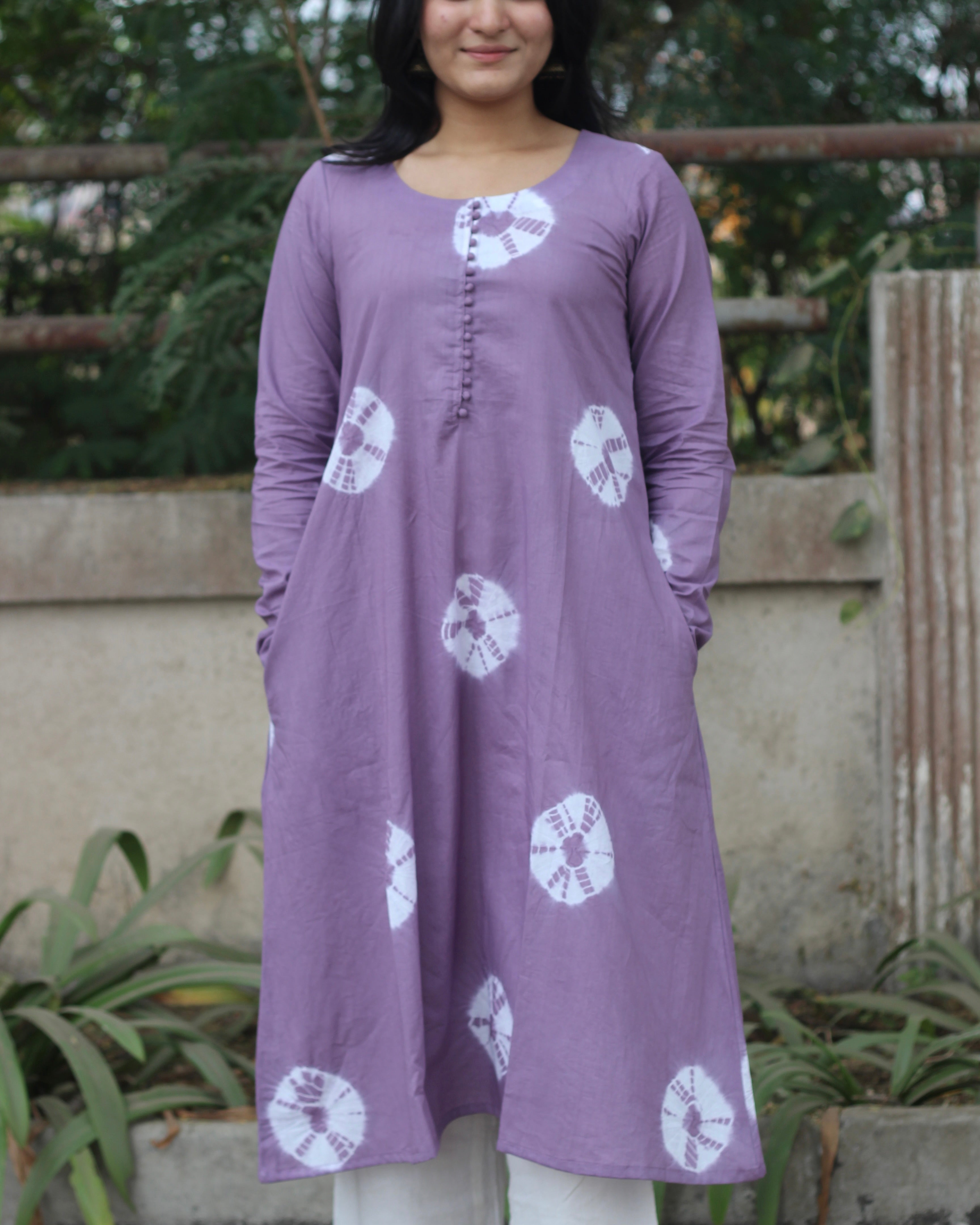 Lavender tie-dye Bandhani cotton kurta with white prints, round neckline, full sleeves, and A-line fit featuring side pockets.