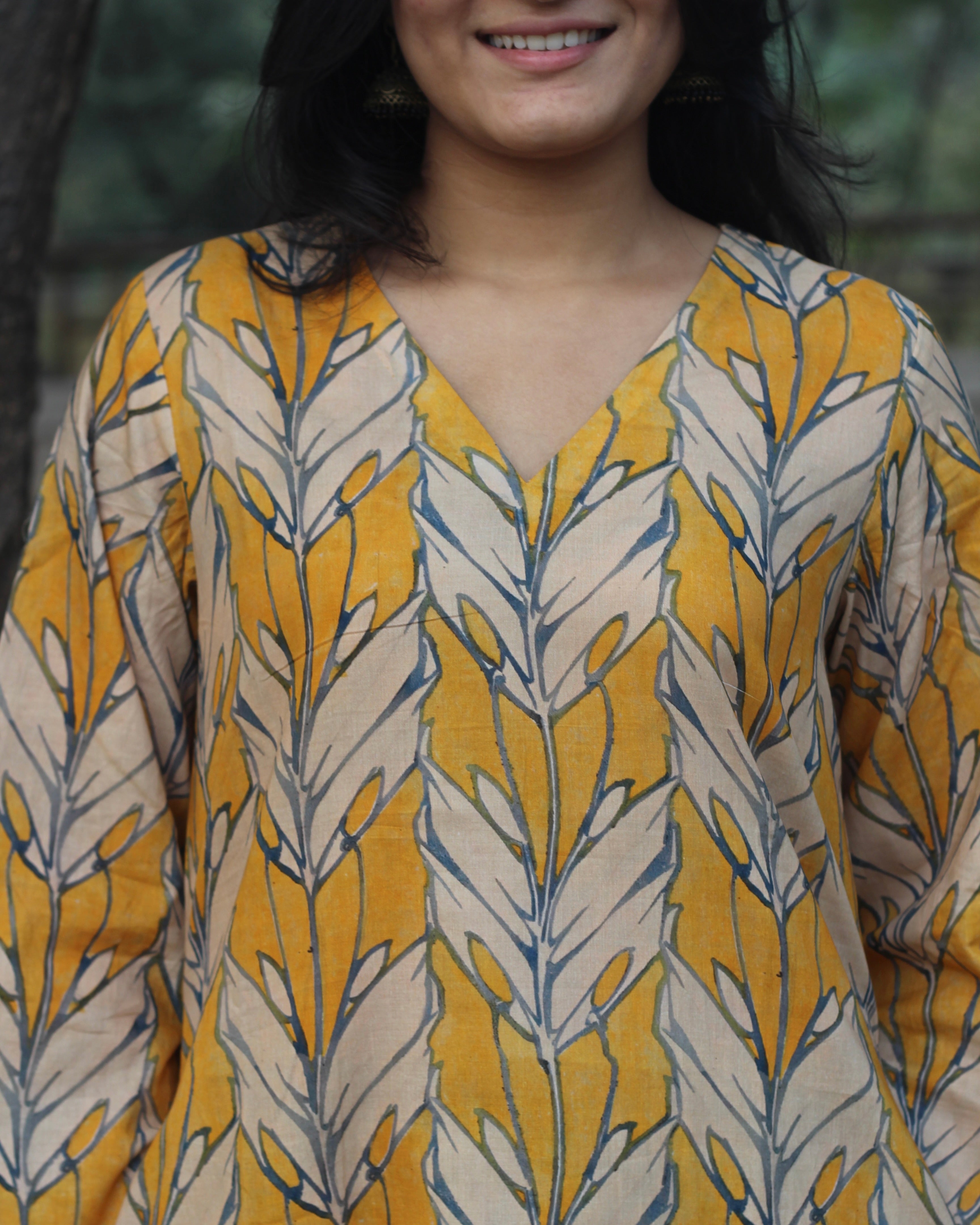 Premium Cotton Kurta and Pant Set in Orange Yellow with White Leaf Print, featuring a V-neckline and pockets.