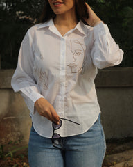 Hand-painted white shirt with bohemian brown leaf motifs, paired with jeans for a stylish look.