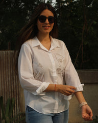 Hand-painted white shirt with bohemian brown leaf motifs, paired with jeans for a stylish look.